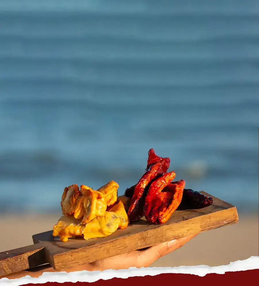 Peperoni cruschi and salt cod on a wooden board by the sea