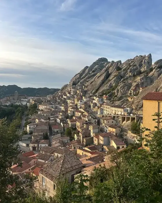 A Lucanian Dolomites village below jagged rock spires in warm morning light